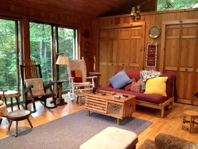 a living room with a couch and a table at Charming Cabin with Serene Lake Views for a Family Getaway near Pittsfield, Massachusetts in Pittsfield