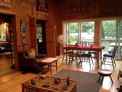 a living room with a table and chairs at Charming Cabin with Serene Lake Views for a Family Getaway near Pittsfield, Massachusetts in Pittsfield