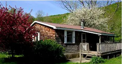 a small house with a porch and a deck at Family-Friendly Cabin Accommodation with Large Yard near Woodstock in Big Indian