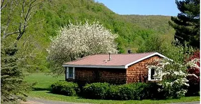 a small brick house in the middle of a mountain at Family-Friendly Cabin Accommodation with Large Yard near Woodstock in Big Indian