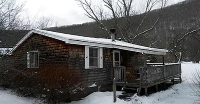 a small house with a snow covered roof at Family-Friendly Cabin Accommodation with Large Yard near Woodstock in Big Indian
