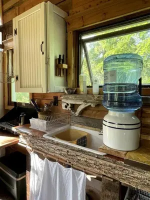 a kitchen counter with a container on top of a sink at Gorgeous Tiny House Rental for a Glamping Getaway near Saratoga Springs in Upstate New York in Argyle
