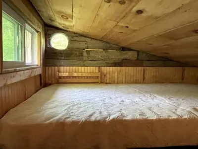 a large bed in a room with a window at Gorgeous Tiny House Rental for a Glamping Getaway near Saratoga Springs in Upstate New York in Argyle