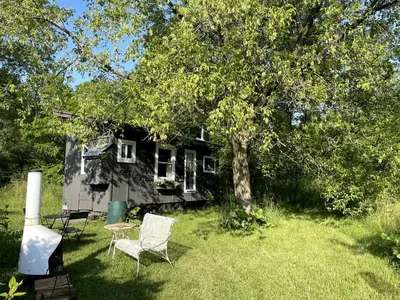 a house with a table and chairs in the yard at Gorgeous Tiny House Rental for a Glamping Getaway near Saratoga Springs in Upstate New York in Argyle