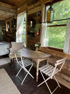 a wooden table and two chairs in a cabin at Gorgeous Tiny House Rental for a Glamping Getaway near Saratoga Springs in Upstate New York in Argyle