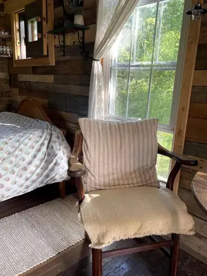 a bedroom with a bed and a chair and a window at Gorgeous Tiny House Rental for a Glamping Getaway near Saratoga Springs in Upstate New York in Argyle