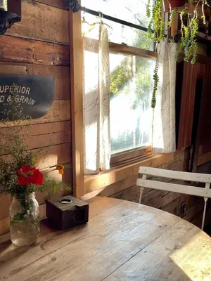 a room with a wooden table with a bench and a window at Gorgeous Tiny House Rental for a Glamping Getaway near Saratoga Springs in Upstate New York in Argyle
