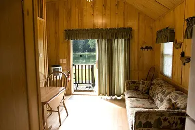 a living room with a couch and a table at Deluxe Vacation Cabin Rentals in the Adirondacks near Saratoga Springs, New York in Corinth