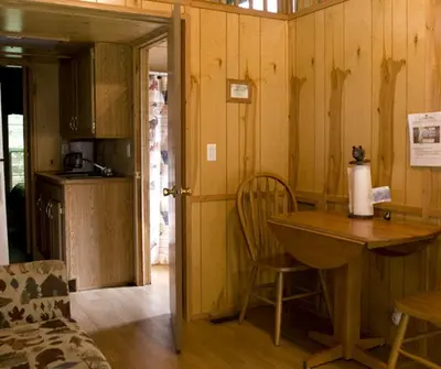 a kitchen with a wooden table and a table and chairs at Deluxe Vacation Cabin Rentals in the Adirondacks near Saratoga Springs, New York in Corinth
