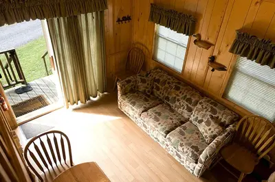 a living room with a couch and a table at Deluxe Vacation Cabin Rentals in the Adirondacks near Saratoga Springs, New York in Corinth