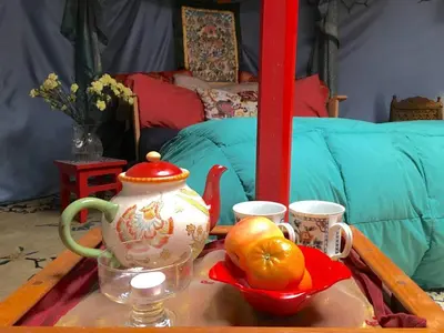 a coffee table with a tea pot and fruit on it at Authentic Mongolian Yurt for a Serene Healing Retreat in Saratoga Springs, New York in Saratoga Springs