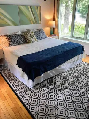 a bedroom with a large bed with a black and white rug at Secluded Cabin with Gorgeous Views near Stockbridge in the Berkshires of Massachusetts in Stockbridge