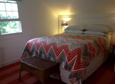 a bedroom with a bed with a colorful blanket on it at Secluded Cabin with Gorgeous Views near Stockbridge in the Berkshires of Massachusetts in Stockbridge