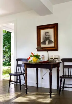 a table with a picture of a man on the wall at Minimalist Countryside Villa Rental near Albany in Upstate New York in West Fulton