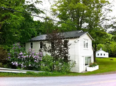 a small white house on the side of a street at Minimalist Countryside Villa Rental near Albany in Upstate New York in West Fulton