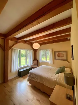 a bedroom with a large bed in a room with wooden ceilings at Beautiful Two-Bedroom Cabin Rental Set in the Forests of the Berkshires, Massachusetts