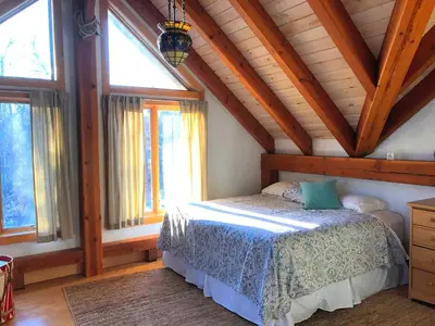 a bedroom with a bed in a room with windows at Beautiful Two-Bedroom Cabin Rental Set in the Forests of the Berkshires, Massachusetts