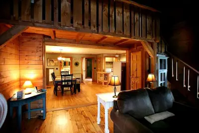 a living room and dining room of a log cabin at Lakefront Cabin Getaway near Adirondack Mountains in Salisbury, New York