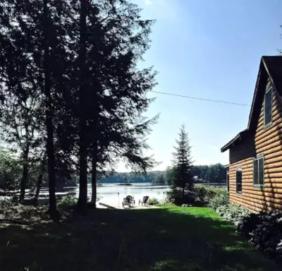 a view of a lake with a house and trees at Lakefront Cabin Getaway near Adirondack Mountains in Salisbury, New York