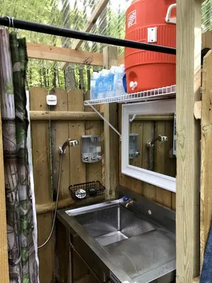 a kitchen with a sink and a mirror at Luxurious Safari Tent in Cooperstown, NY - Perfect Glamping Spot for a Romantic Getaway in Cooperstown