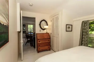 a bedroom with a bed and a dresser and a table at Riverfront Cabin with Beautiful Views of Housatonic River in Great Barrington, Massachusetts in Housatonic