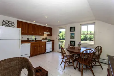 a kitchen with a table and a white refrigerator at Riverfront Cabin with Beautiful Views of Housatonic River in Great Barrington, Massachusetts in Housatonic