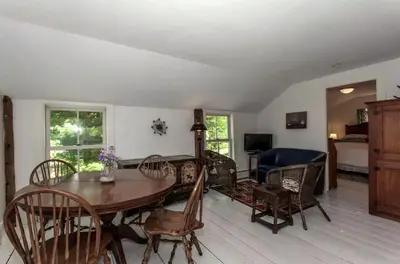 a living room with a table and chairs and a bedroom at Riverfront Cabin with Beautiful Views of Housatonic River in Great Barrington, Massachusetts in Housatonic