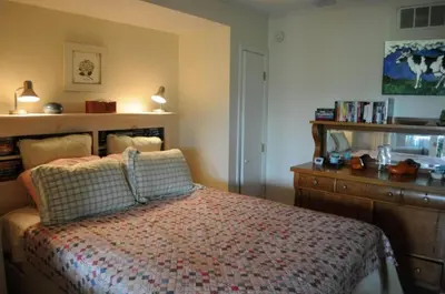 a bedroom with a bed with a wooden dresser and a bed sidx sidx sidx at Impressive Cabin with a Pool and Hot Tub Ideal for Weekend Getaways in the Catskills in Hunter