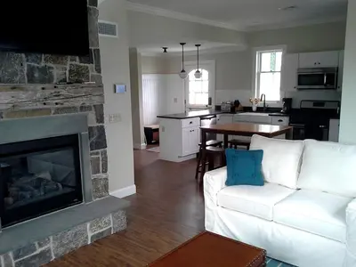 a living room with a white couch and a fireplace at Spacious Guest Cottage Rental on Lake in Berkshires, Massachusetts in Lanesborough