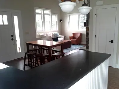 a kitchen with a table and a living room at Spacious Guest Cottage Rental on Lake in Berkshires, Massachusetts in Lanesborough