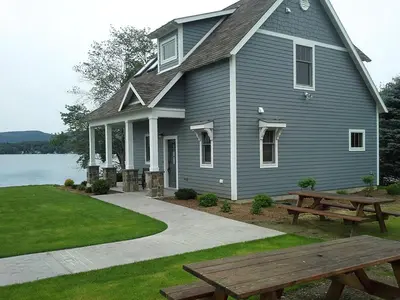 a house with a picnic table and a bench at Spacious Guest Cottage Rental on Lake in Berkshires, Massachusetts in Lanesborough
