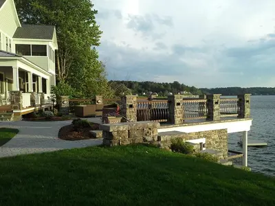 a house with a bridge over a body of water at Four-Bedroom Luxury House Rental on Pontoosuc Lake in the Berkshires in Lanesborough