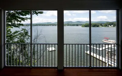 a view of a lake from a house balcony at Four-Bedroom Luxury House Rental on Pontoosuc Lake in the Berkshires in Lanesborough