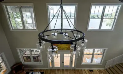 a chandelier hanging in a room with windows at Four-Bedroom Luxury House Rental on Pontoosuc Lake in the Berkshires in Lanesborough
