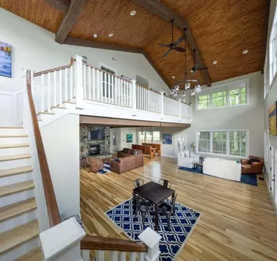 a large room with a staircase and a living room at Four-Bedroom Luxury House Rental on Pontoosuc Lake in the Berkshires in Lanesborough