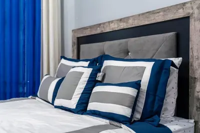 a bed with blue and white pillows on it at Newark 3BR Gem - Near NYC - & Attractions in Newark