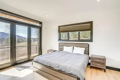 a bedroom with a large bed and large windows at Lux Windham Getaway - Views & Indoor Heated Pool in Windham