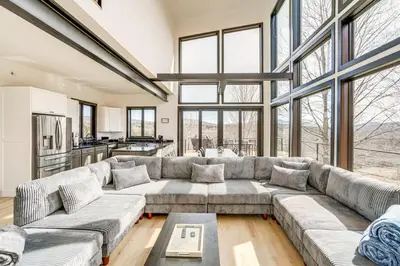 a large living room with a large couch and windows at Lux Windham Getaway - Views & Indoor Heated Pool in Windham