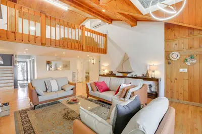 a living room with white furniture and a wooden ceiling at Lake Carmel Access Waterfront Home with Deck! in Carmel