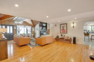 a large living room with wooden floors and furniture at Lake Carmel Access Waterfront Home with Deck! in Carmel