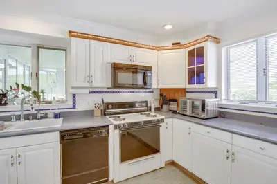 a kitchen with white cabinets and stainless steel appliances at Lake Carmel Access Waterfront Home with Deck! in Carmel