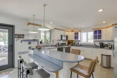 a large kitchen with a large counter top and chairs at Lake Carmel Access Waterfront Home with Deck! in Carmel