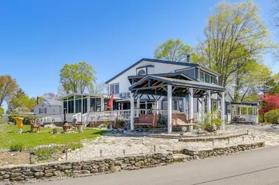 a large white house with a porch on a street at Lake Carmel Access Waterfront Home with Deck! in Carmel