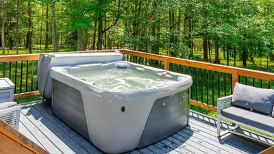 a bath tub sitting on a deck with a chair at PoolHot Tub Firepit Near Hikes Shops Dining Cragswood Lodge by AvantStay in New Paltz
