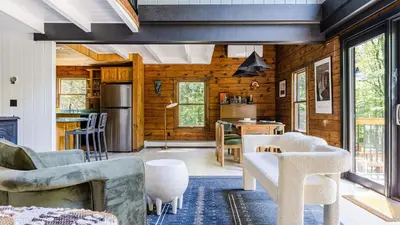 a living room with wood paneling and a kitchen at PoolHot Tub Firepit Near Hikes Shops Dining Cragswood Lodge by AvantStay in New Paltz