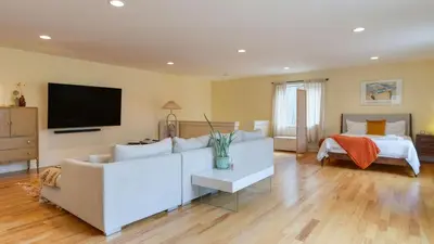 a living room with a white couch and a bed at PoolHot Tub Firepit Near Hikes Shops Dining Cragswood Lodge by AvantStay in New Paltz