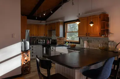 a kitchen with wooden cabinets and a black counter top at Four Season Retreat in Heart of the Catskills in Fleischmanns