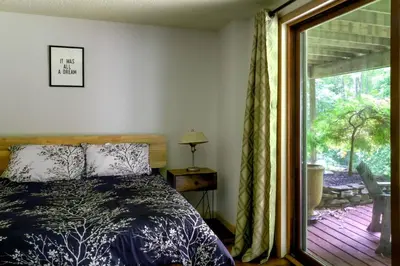 a bedroom with a bed next to a sliding glass door at Four Season Retreat in Heart of the Catskills in Fleischmanns