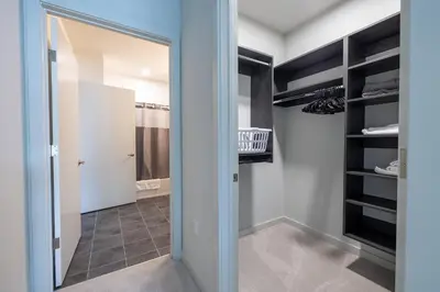 a walk in closet with a mirror and a door at Luxury Apt Downtown in White Plains