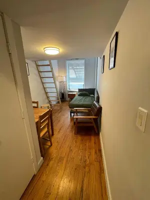 a room with a bed and a table and a staircase at Union Square Studio 4 with Shower - Shared toilet in New York